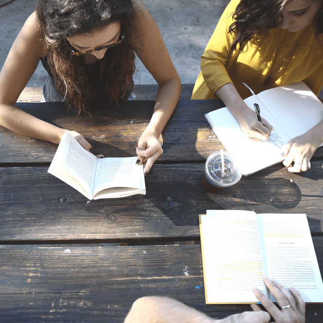 A view from above of people writing and reading. 